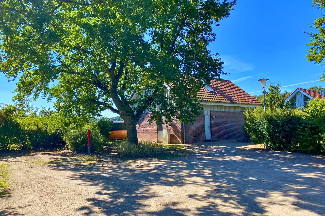 Rotes Backsteinhaus unter alten Bäumen – idyllisch gelegenes Ferienhaus mit Naturanschluss und viel Privatsphäre.