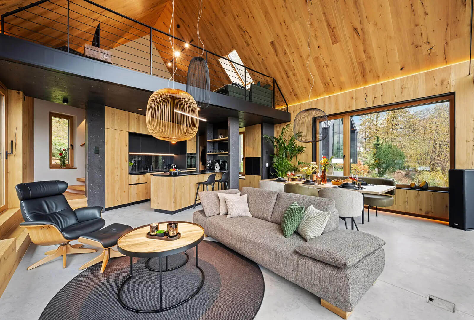 Exklusives Design-Ferienhaus mit offener Galerie, moderner Küche und Panoramafenster – luxuriöses Interieur aus Holz, Beton und Glas