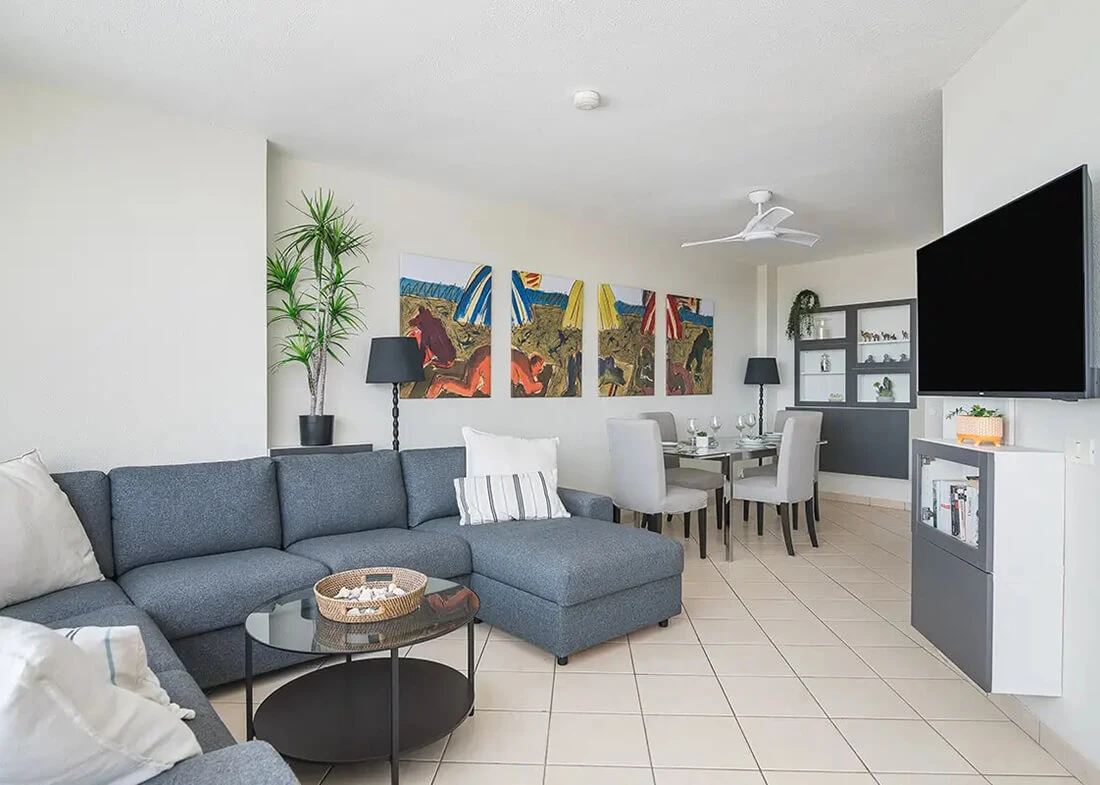 Helles Wohnzimmer im Casa LEX Penthouse mit Sofa, Esstisch und Fernseher.