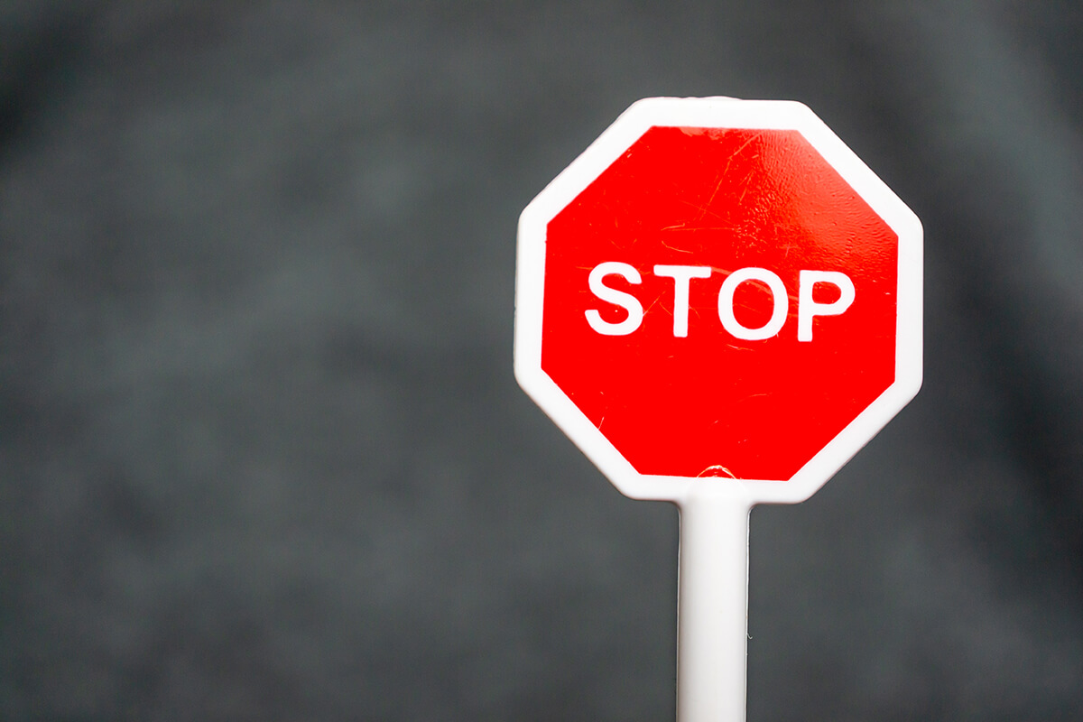 Rotes Stoppschild aus Kunststoff vor dunklem Hintergrund
