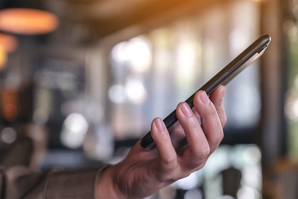 Hand hält Smartphone – Google Maps Betrug Anruf bei einem Vermieter von Ferienwohnungen