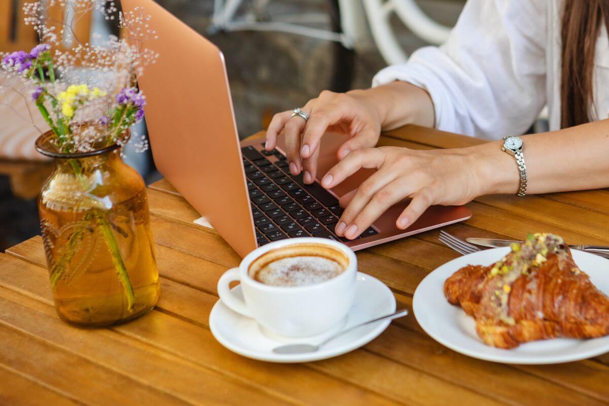 Digitales Arbeiten mit Laptop und Frühstück im charmanten Café