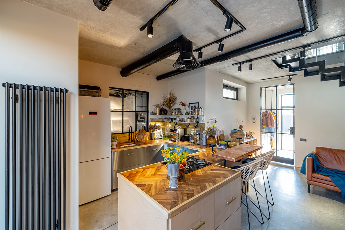 Moderne Ferienwohnung im Industriestil mit Holzinsel, Betondecke und natürlichen Akzenten