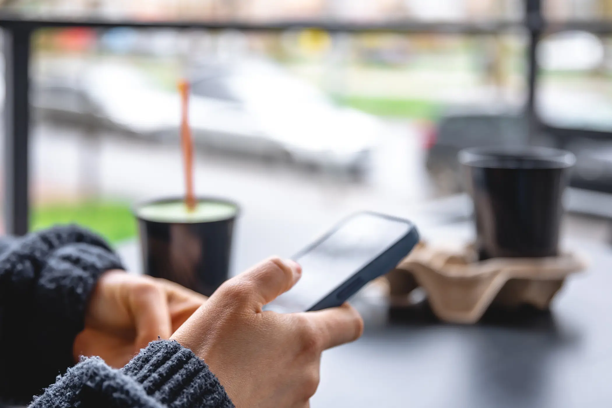 Social Media als Discovery-Kanal für Ferienwohnungsvermieter – Smartphone im Café