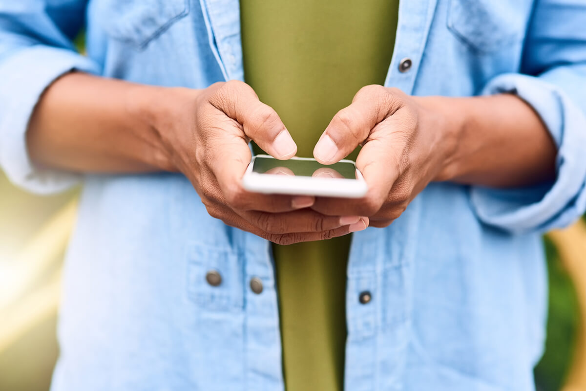 Person nutzt Smartphone – Social Media als Suchmaschine für Ferienwohnungen