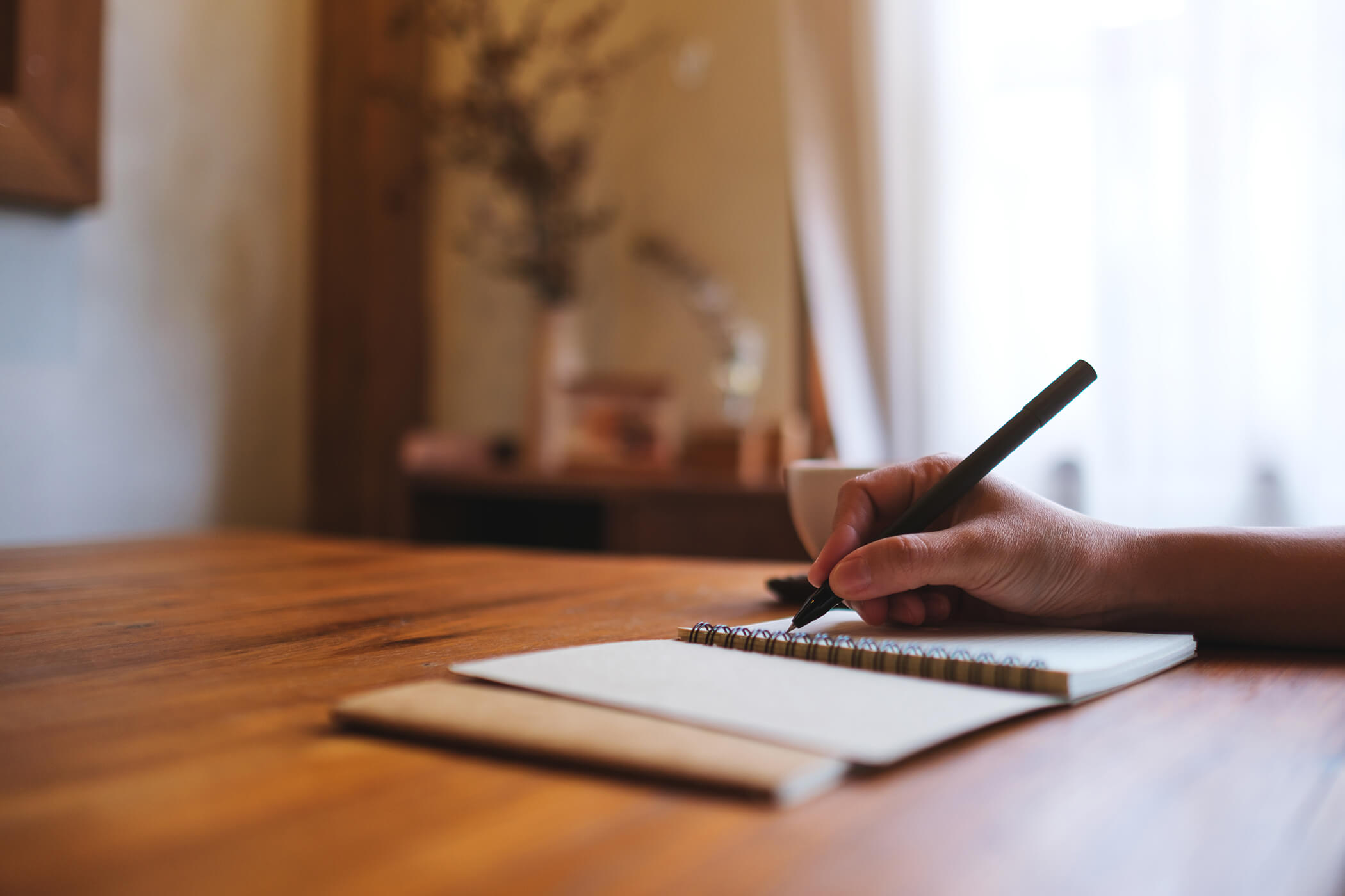 Notizbuch und Stift auf Holztisch – Reflexion für Gastgeber und Kurzzeitvermieter